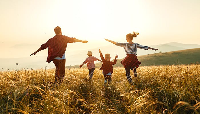 Family in open field running together