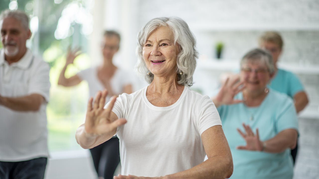 A group of seniors are doing tai chi together.