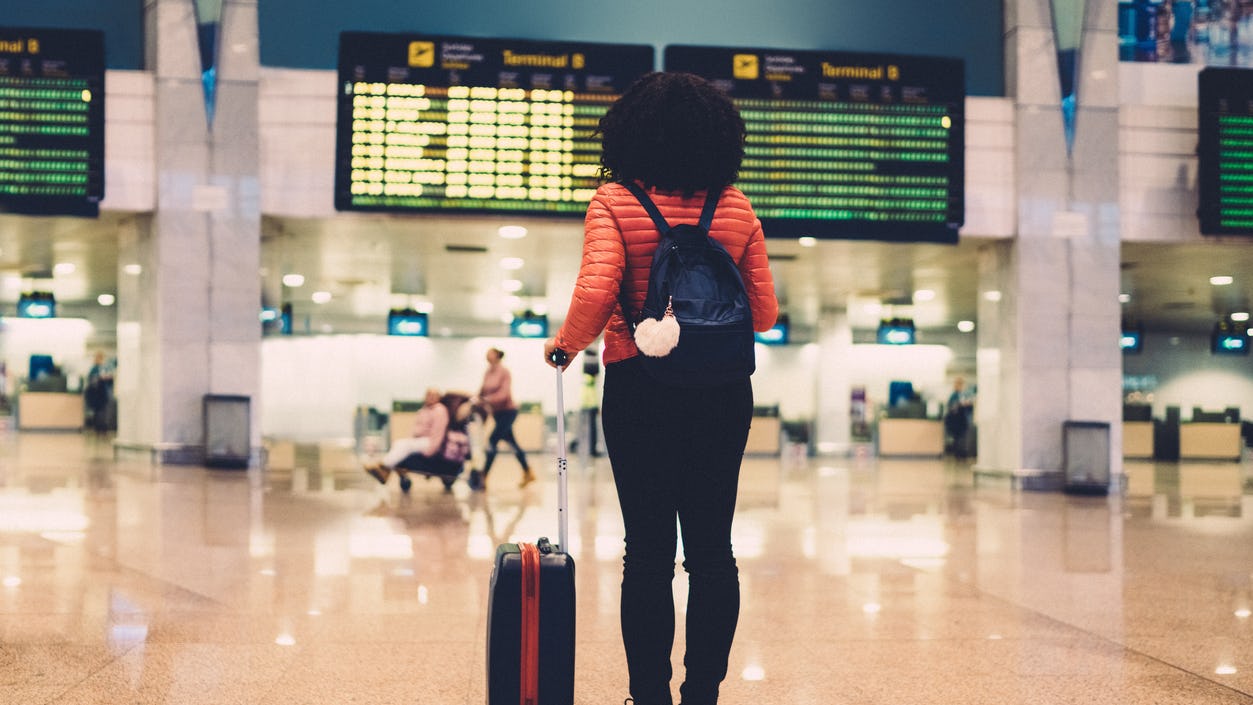 Woman standing at the airport with her luggage