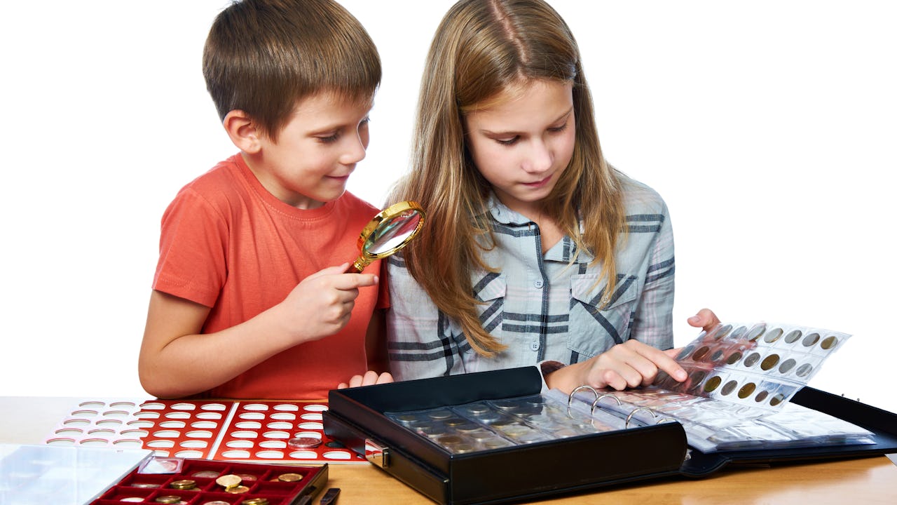 Two children looking at a coin collection