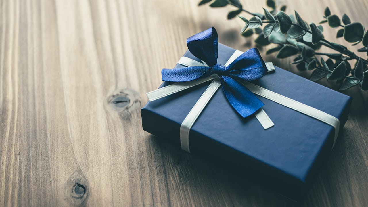 Gift box with a beautiful bow on a wooden surface