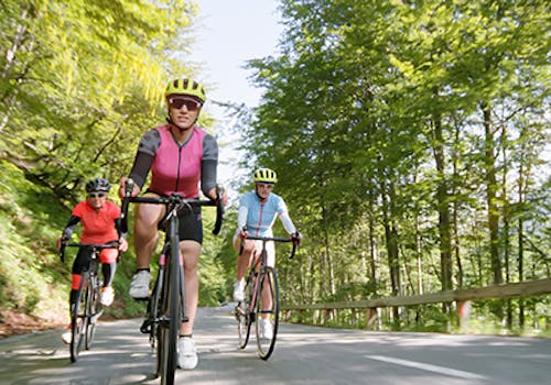 People cycling on open road