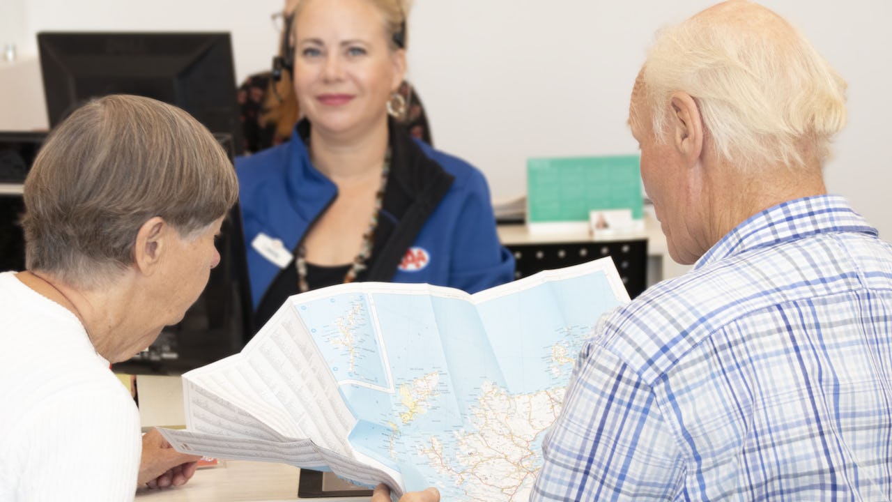 Couple browsing a map at a CAA Travel store