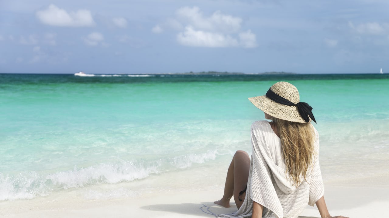 Woman sitting on beach in Bahamas
