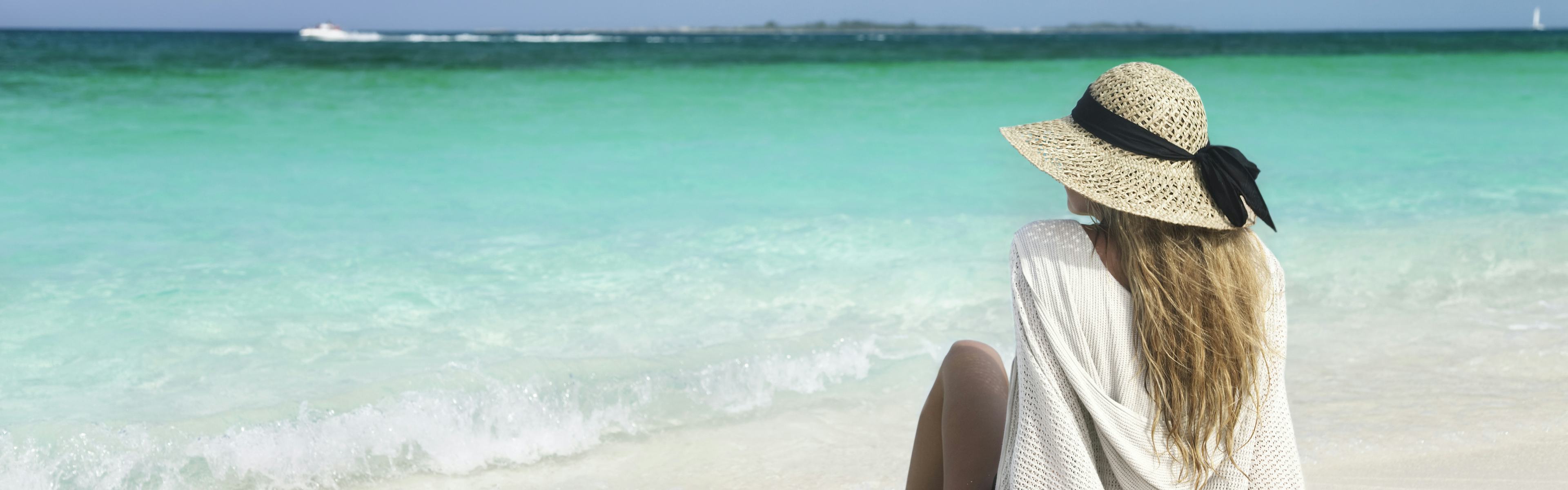 Woman sitting on beach in Bahamas