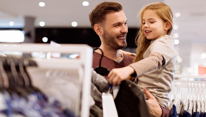 Dad shopping for clothes with young daughter