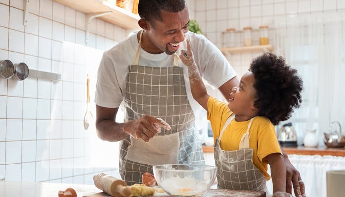 Father baking with young son in kitchen