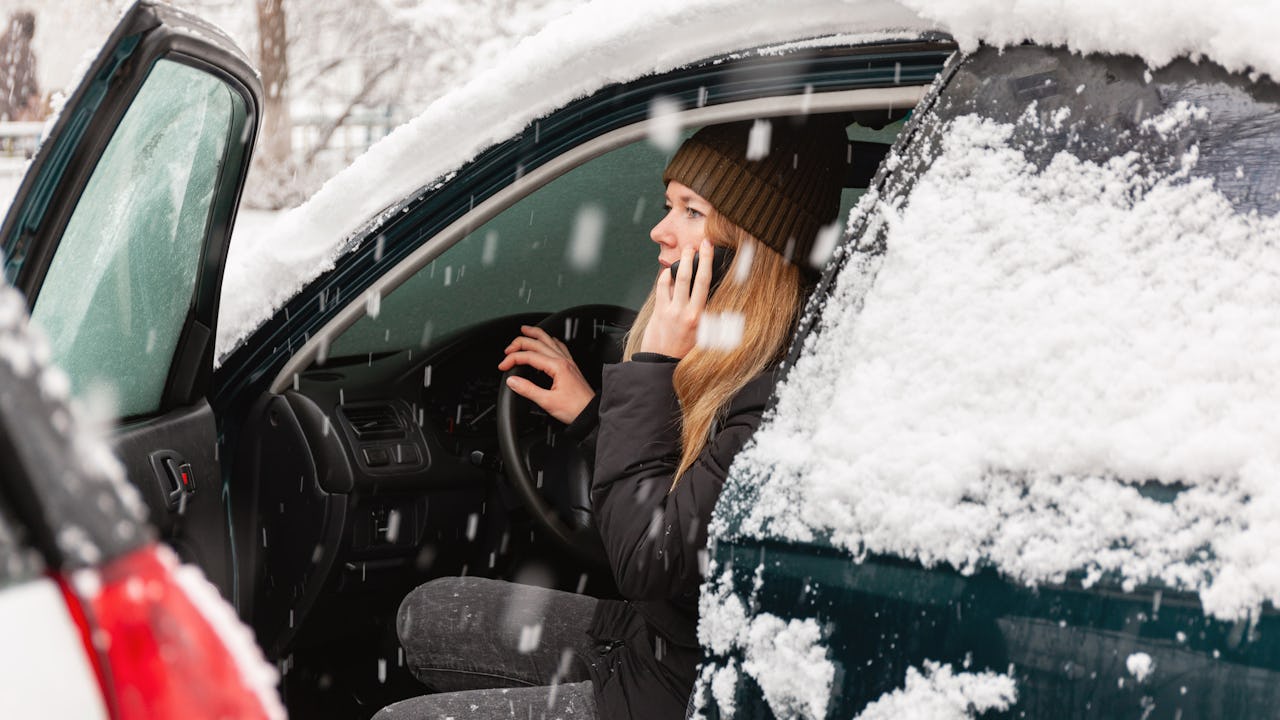 Woman calling for help in a snow covered car