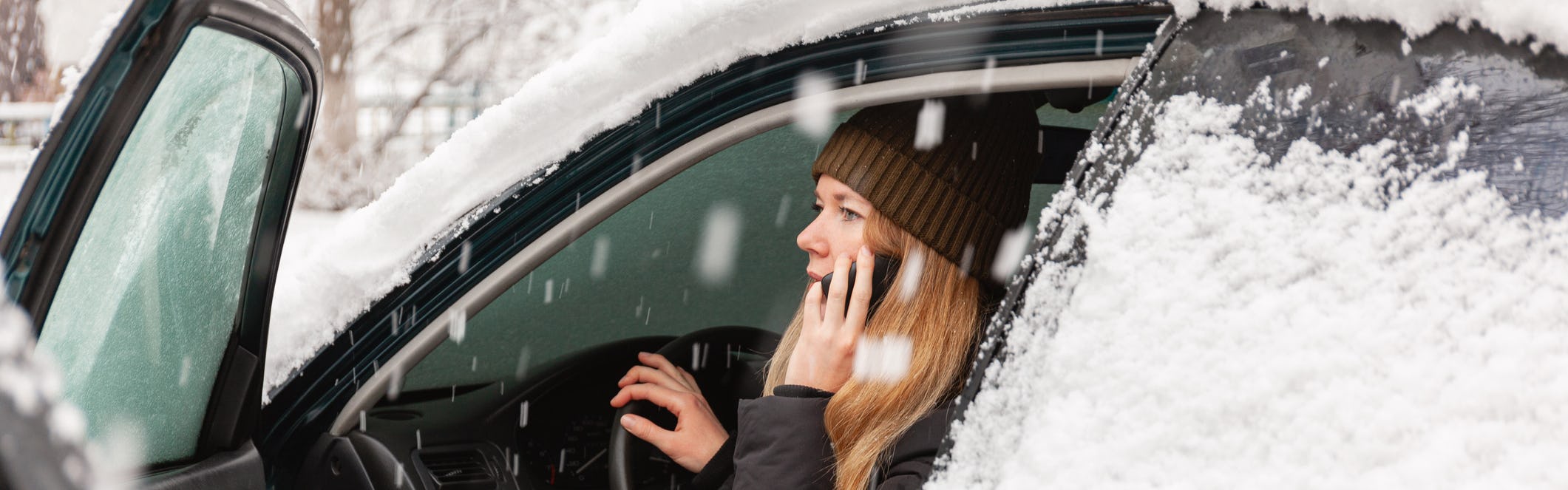 Woman calling for help in a snow covered car