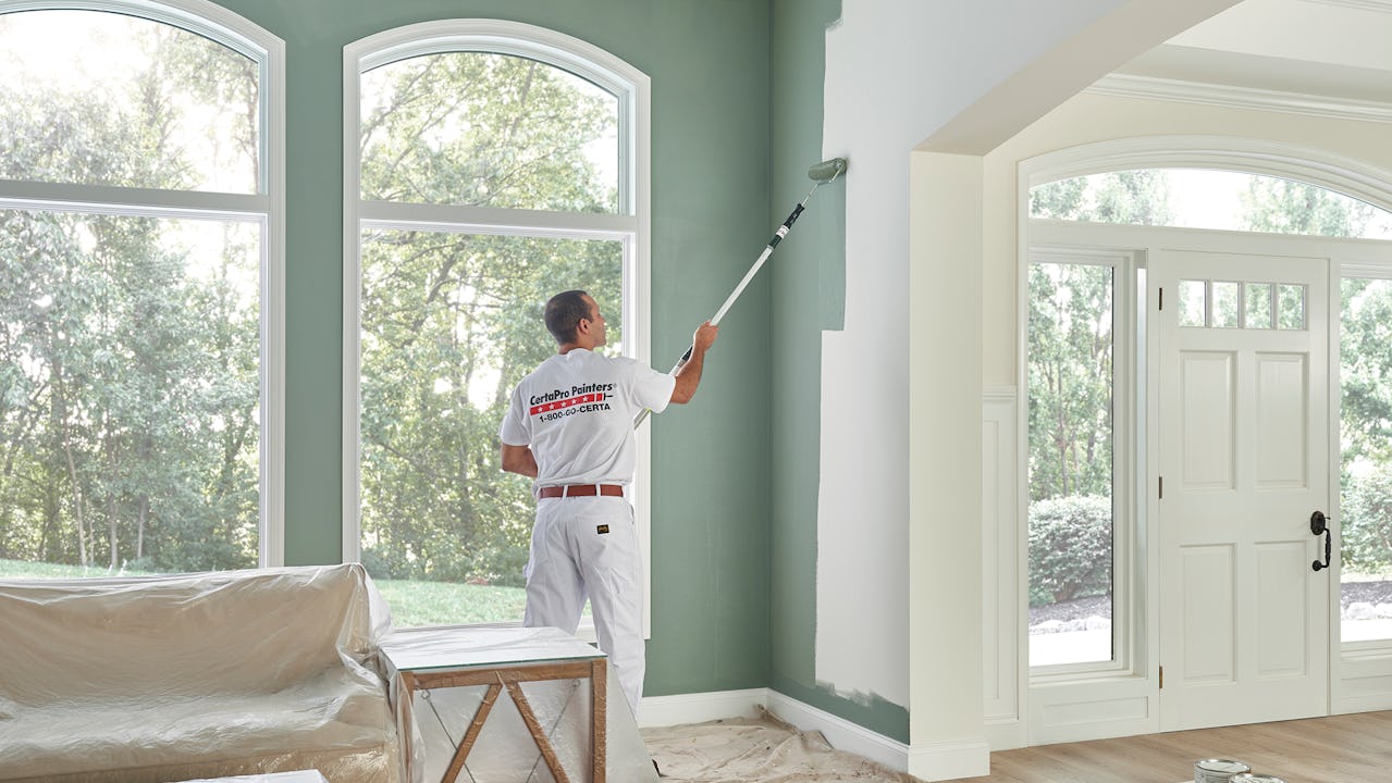 A picture of a professional painter painting a wall