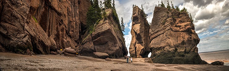 Two people walking on the beach at the Bay of Fundy, Canada