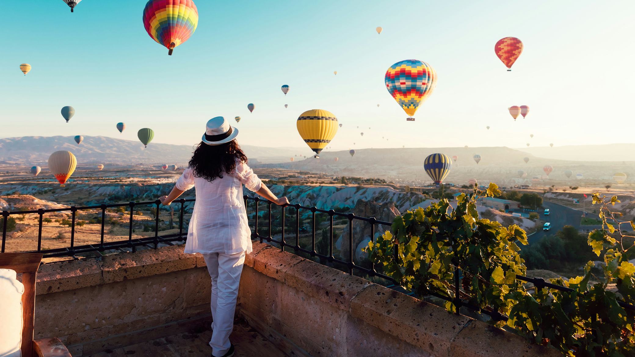 Woman watching hot air balloons fly in Cappadocia, Turkey 