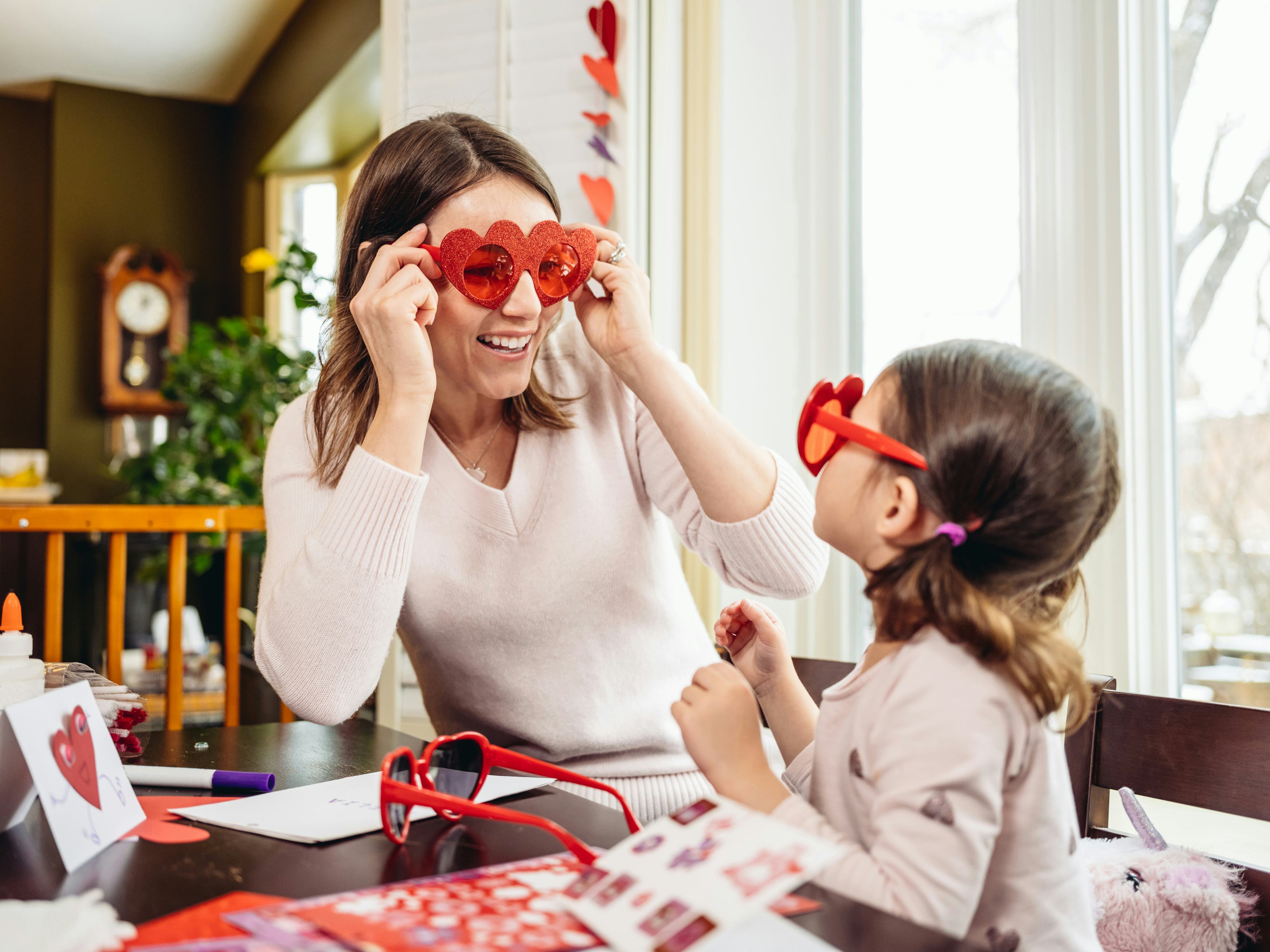Mother and daughter wearing heart shaped sunglasses