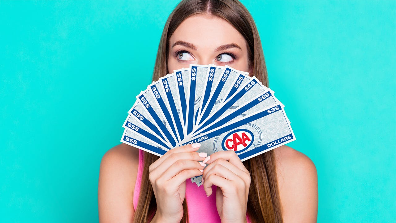 Woman holding a fan of CAA Dollar bills
