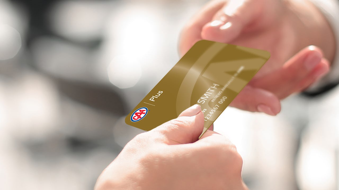 Person handing over their CAA Plus Membership card