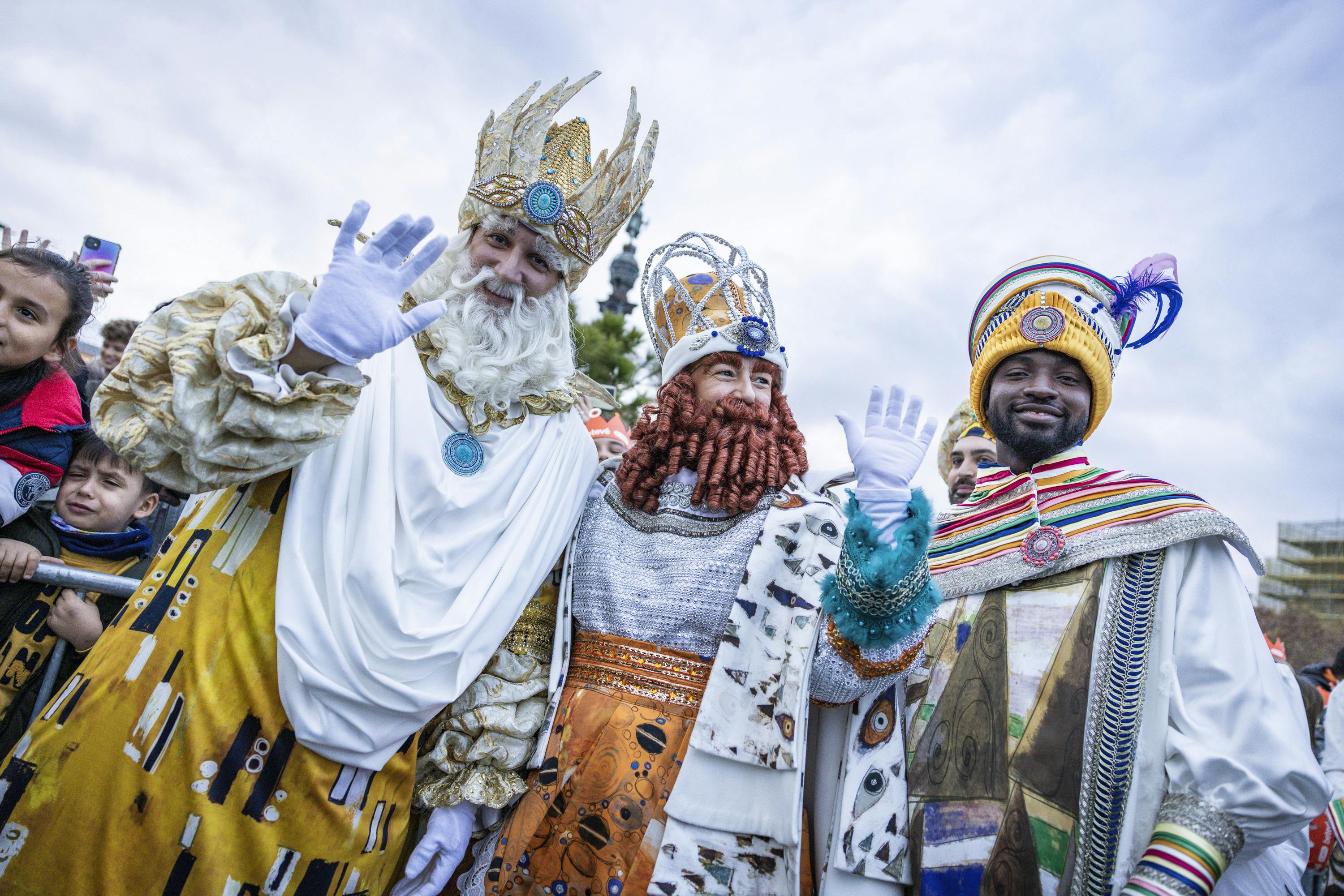 Three men dressed as Reyes Magos wearing crowns, celebrating the birth of baby Jesus.