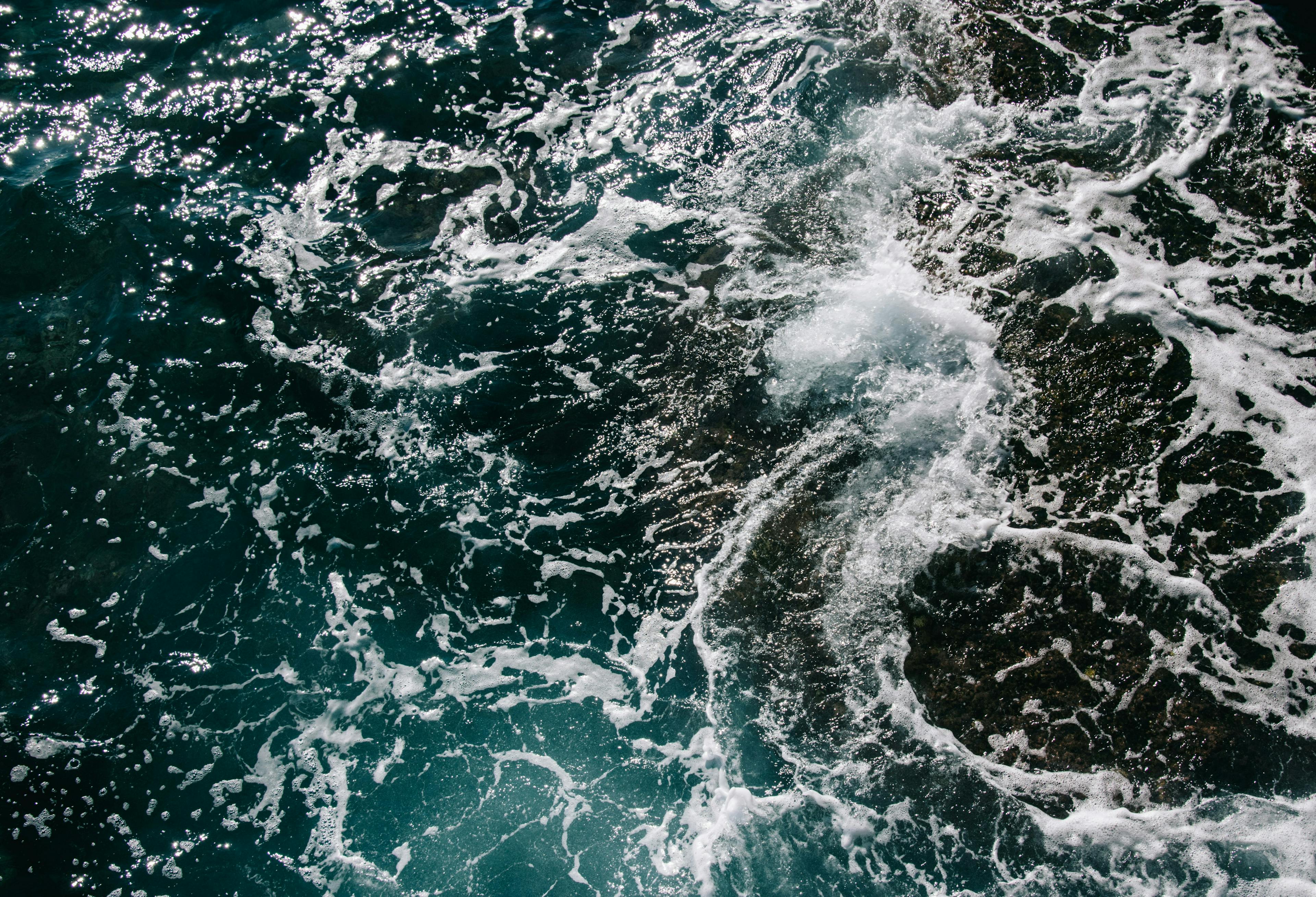 An aerial view of the ocean waves crashing against the shores of Salou, Spain.