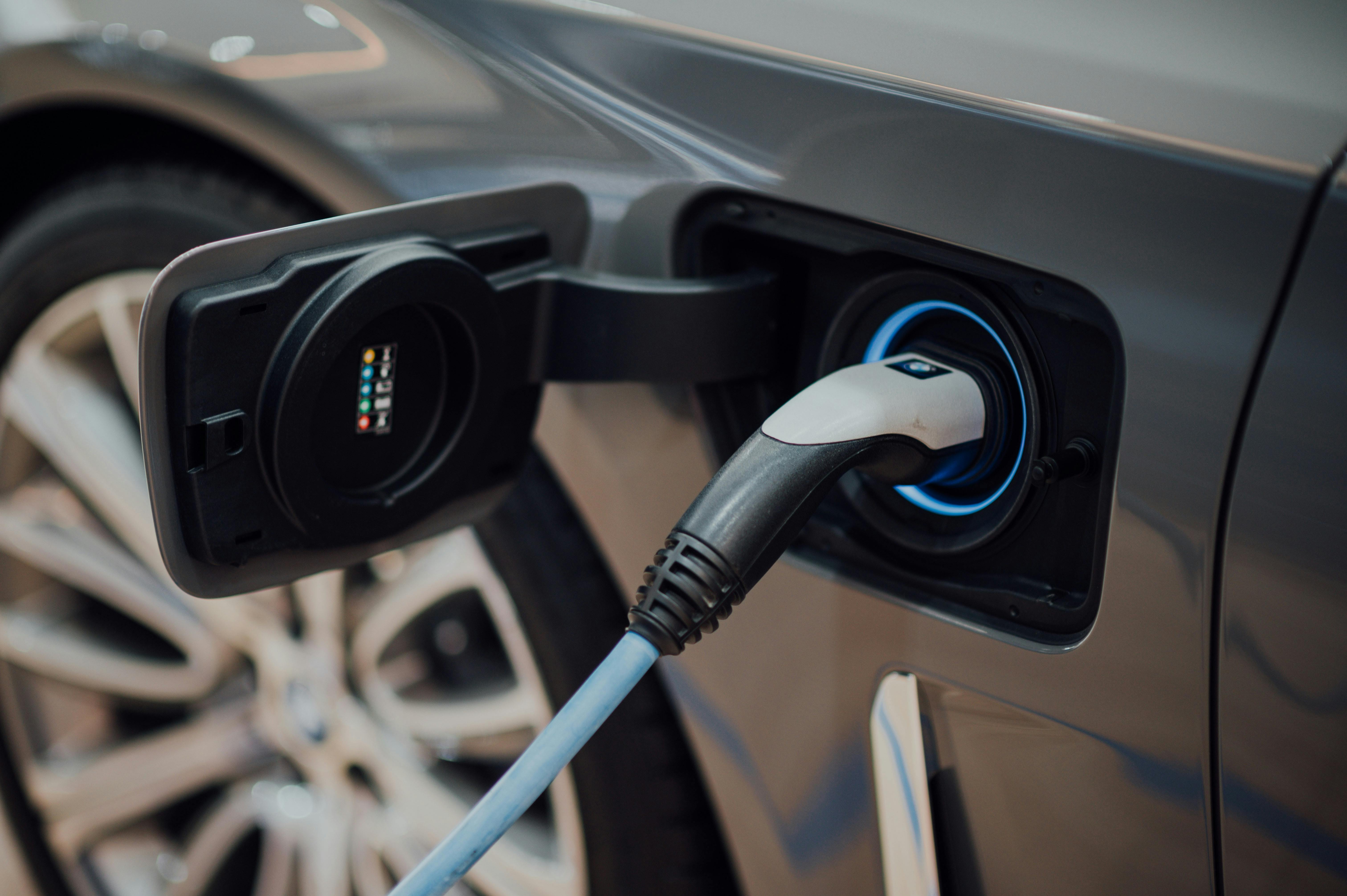 An electric car being charged by an electric charger.