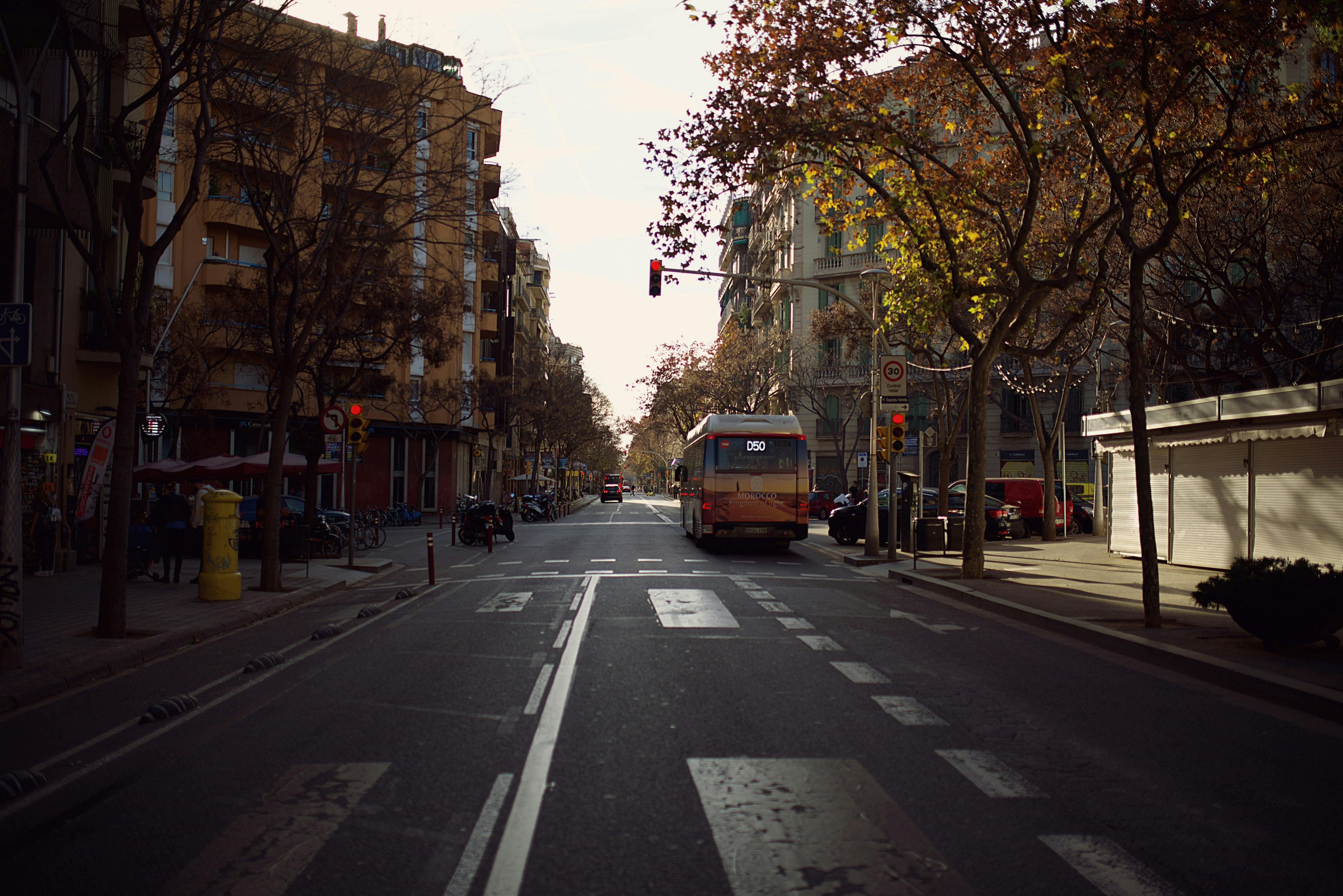 A Barcelona street with a city bus traversing through it.