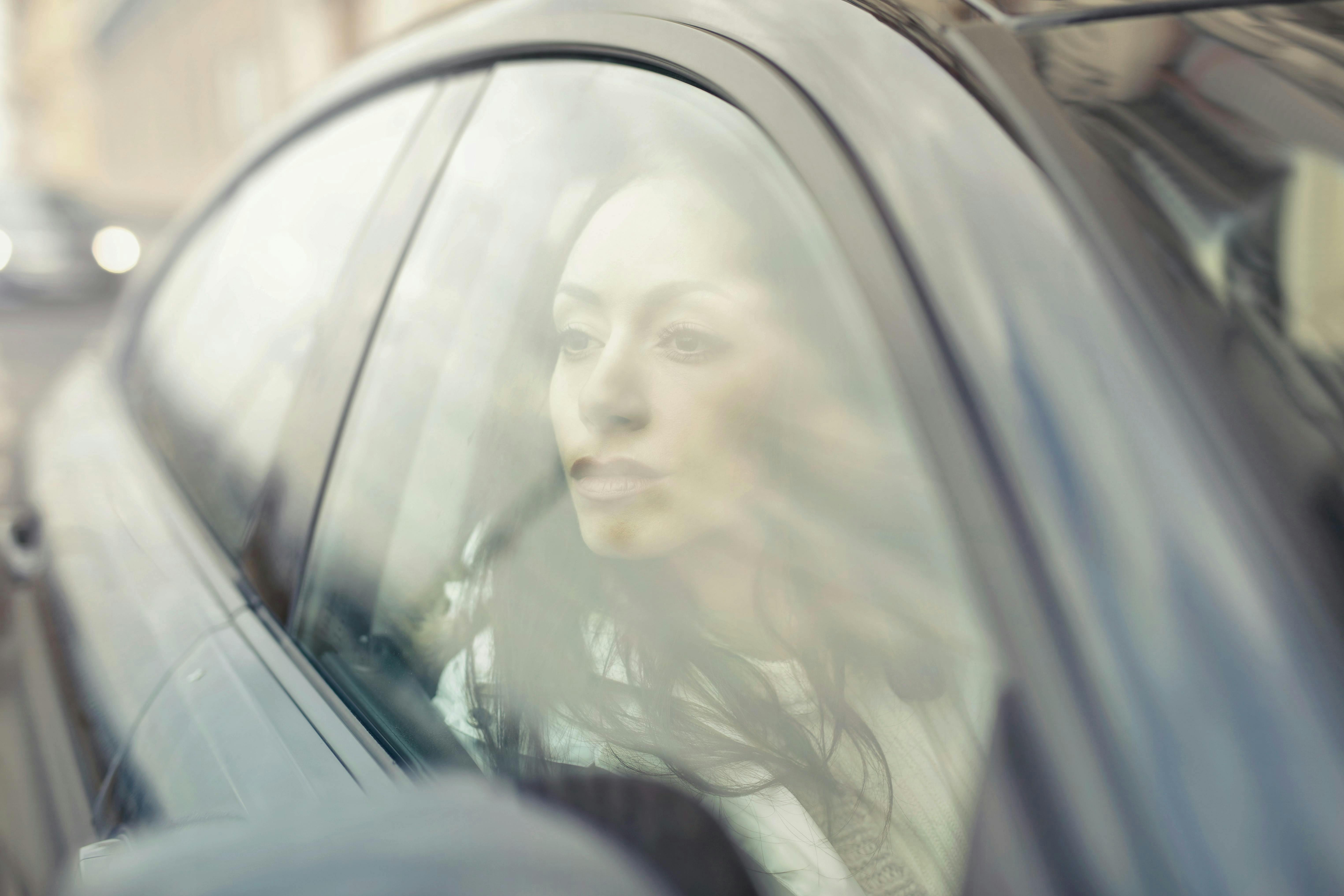 Passenger in a taxi looking out the window during a trip.