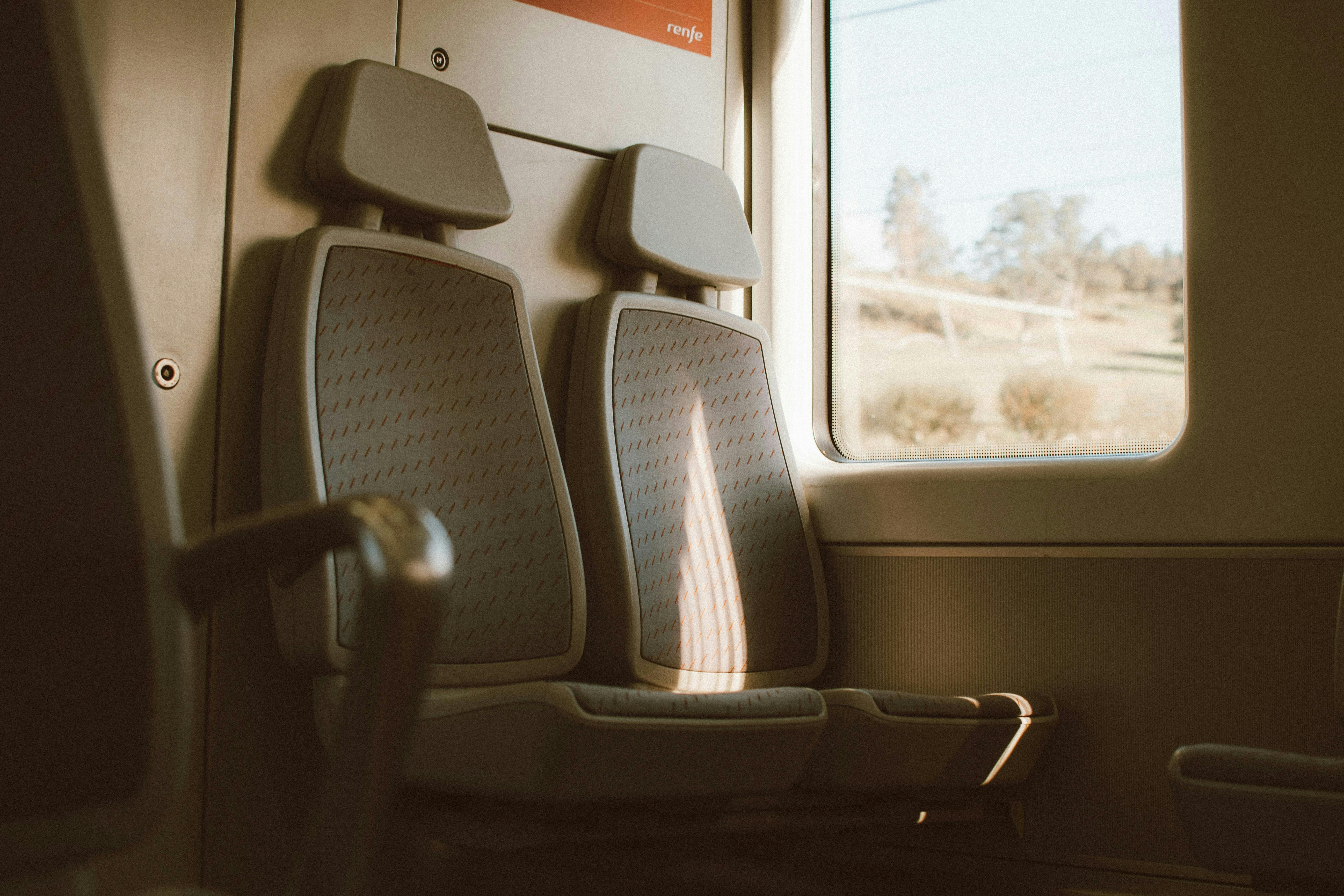 Details of the interior of a train, showcasing the scenery outside through the windows.