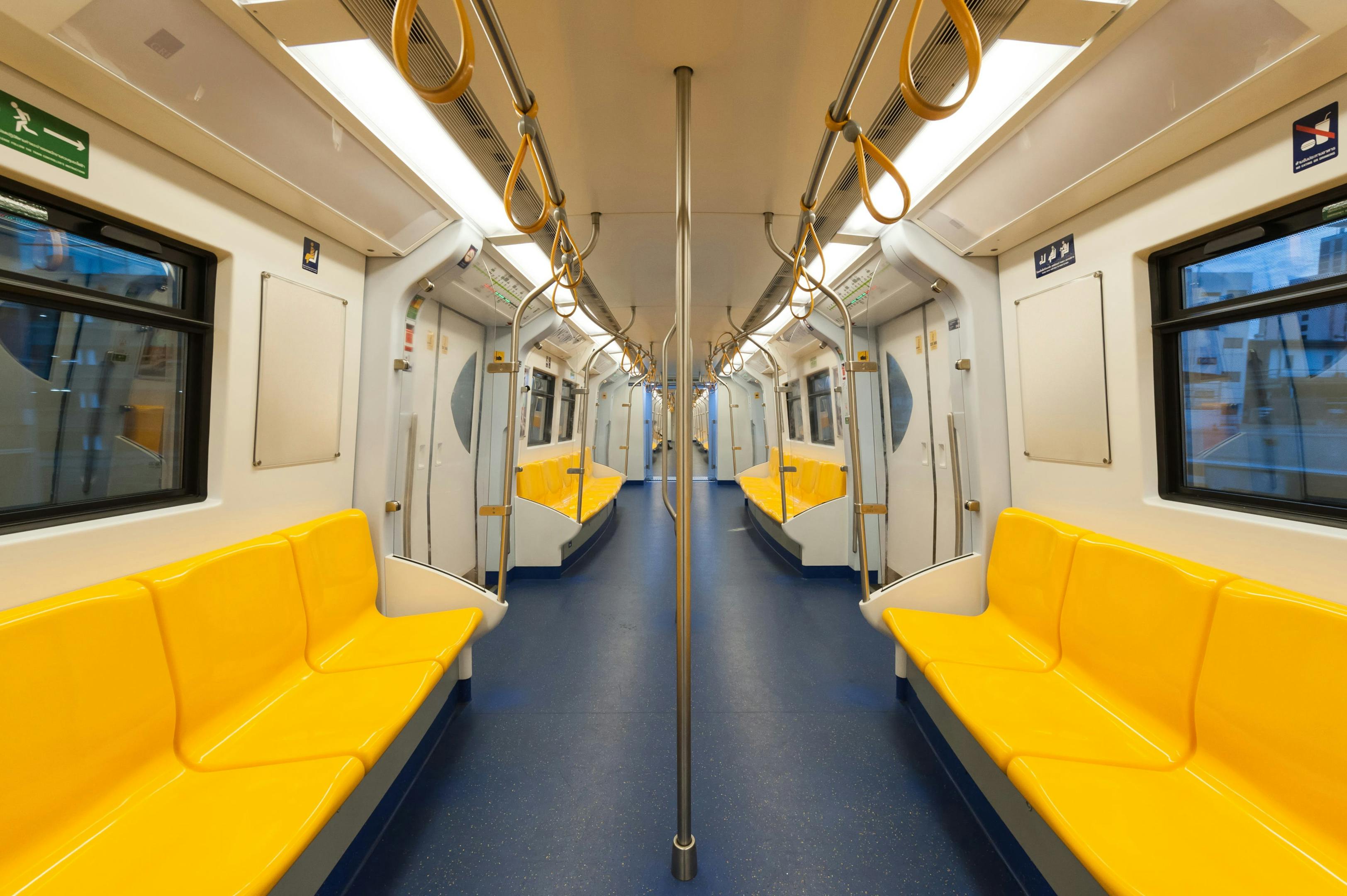 A train car with yellow seats and blue floor, part of a public transport service.