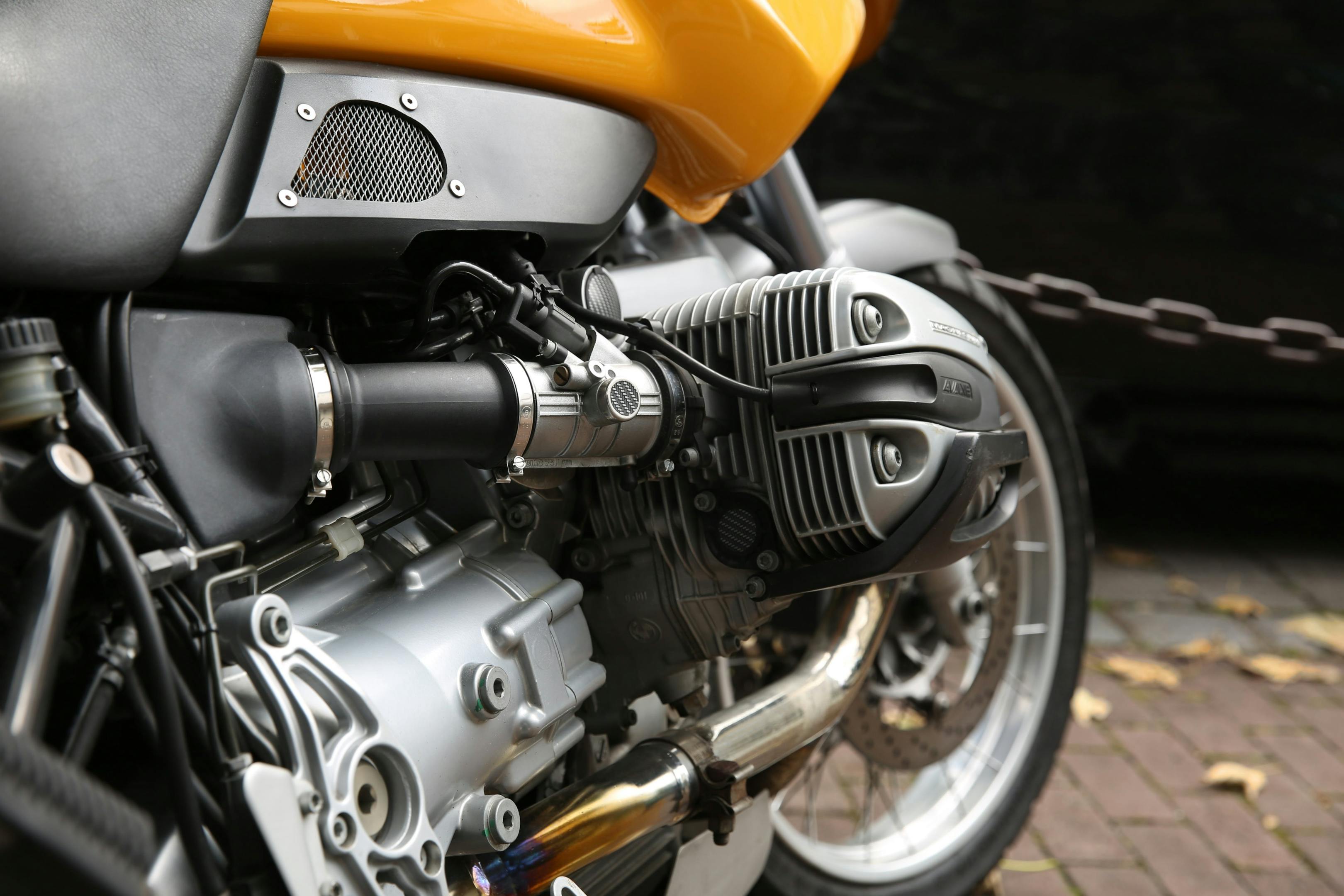 A yellow motorbike, used for transport, parked on a road.