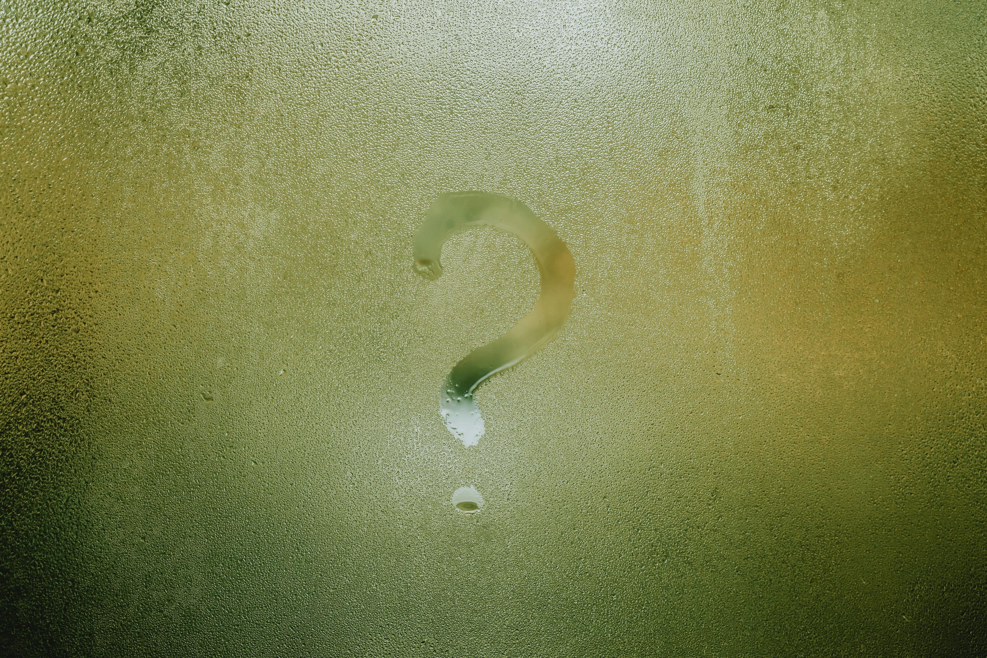 A question mark on a window, symbolizing inquiries about money and financial matters.