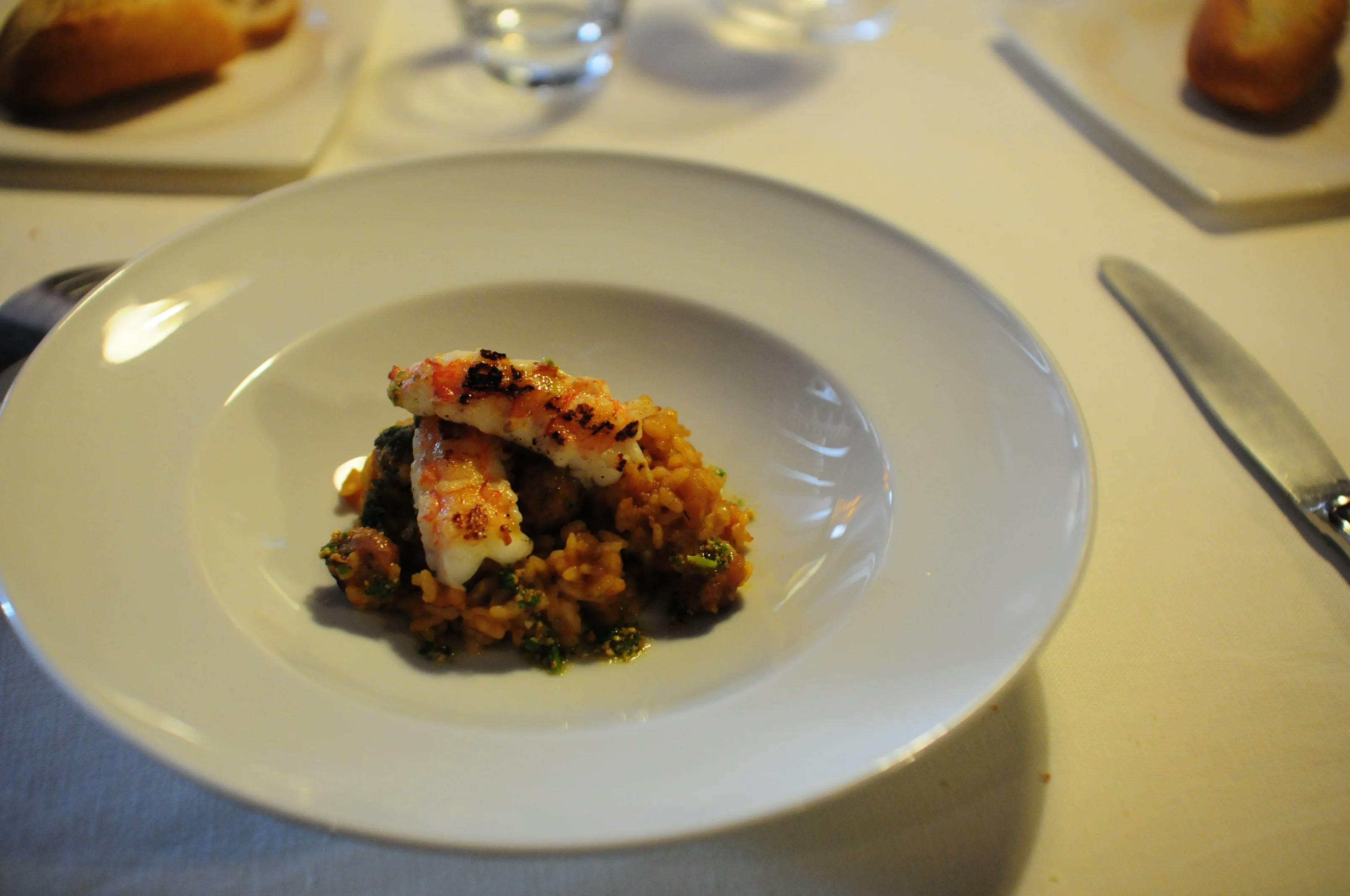 A delectable dish served on a white plate at Bresca Restaurant, a restaurant near Salou, showcasing mouthwatering food.