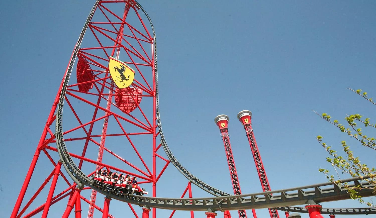 A thrilling roller coaster ride at PortAventura Theme Park featuring a red and black car.