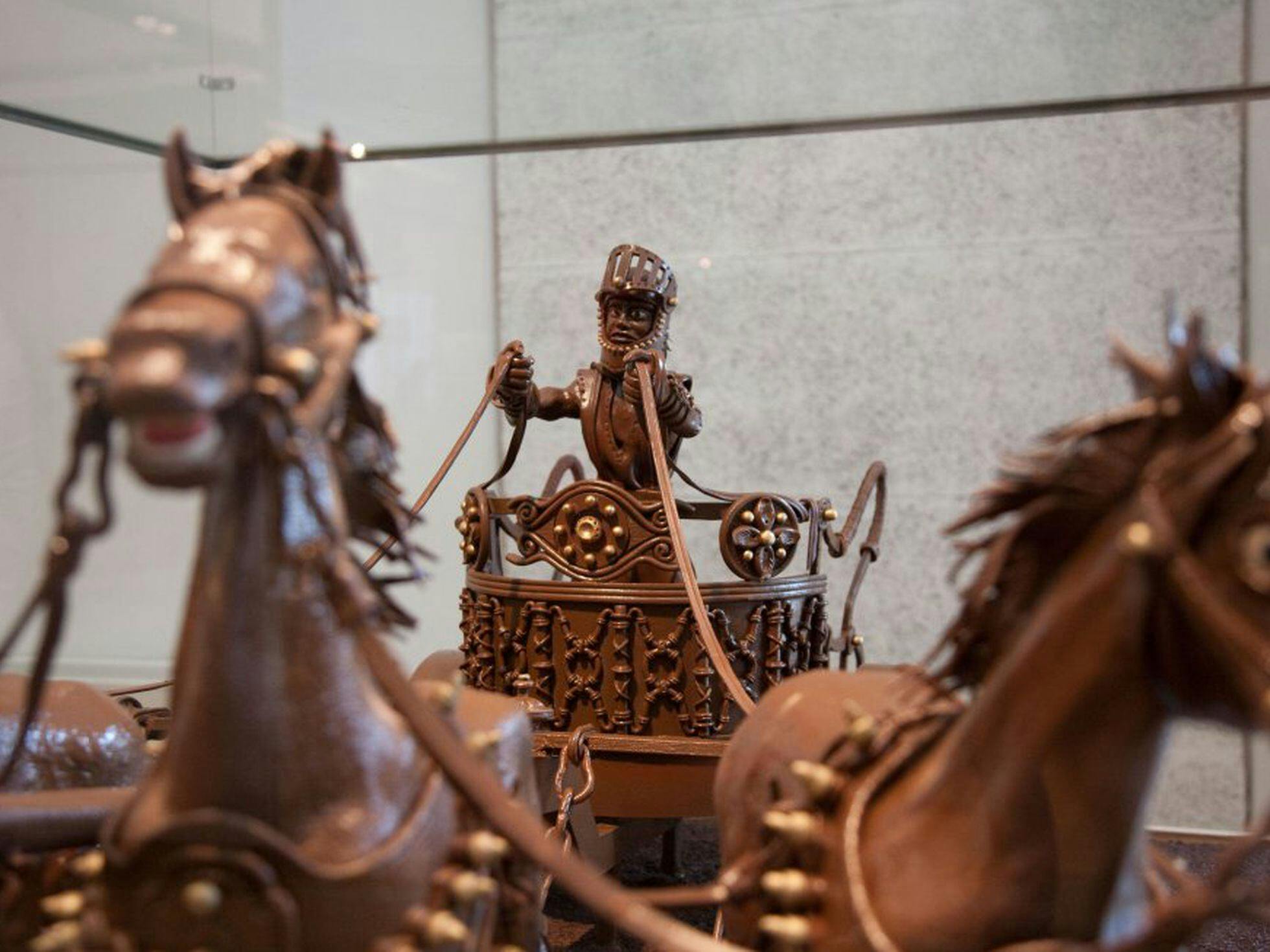 A chocolate horse carriage with a man riding on it at Museu de la Xocolata.