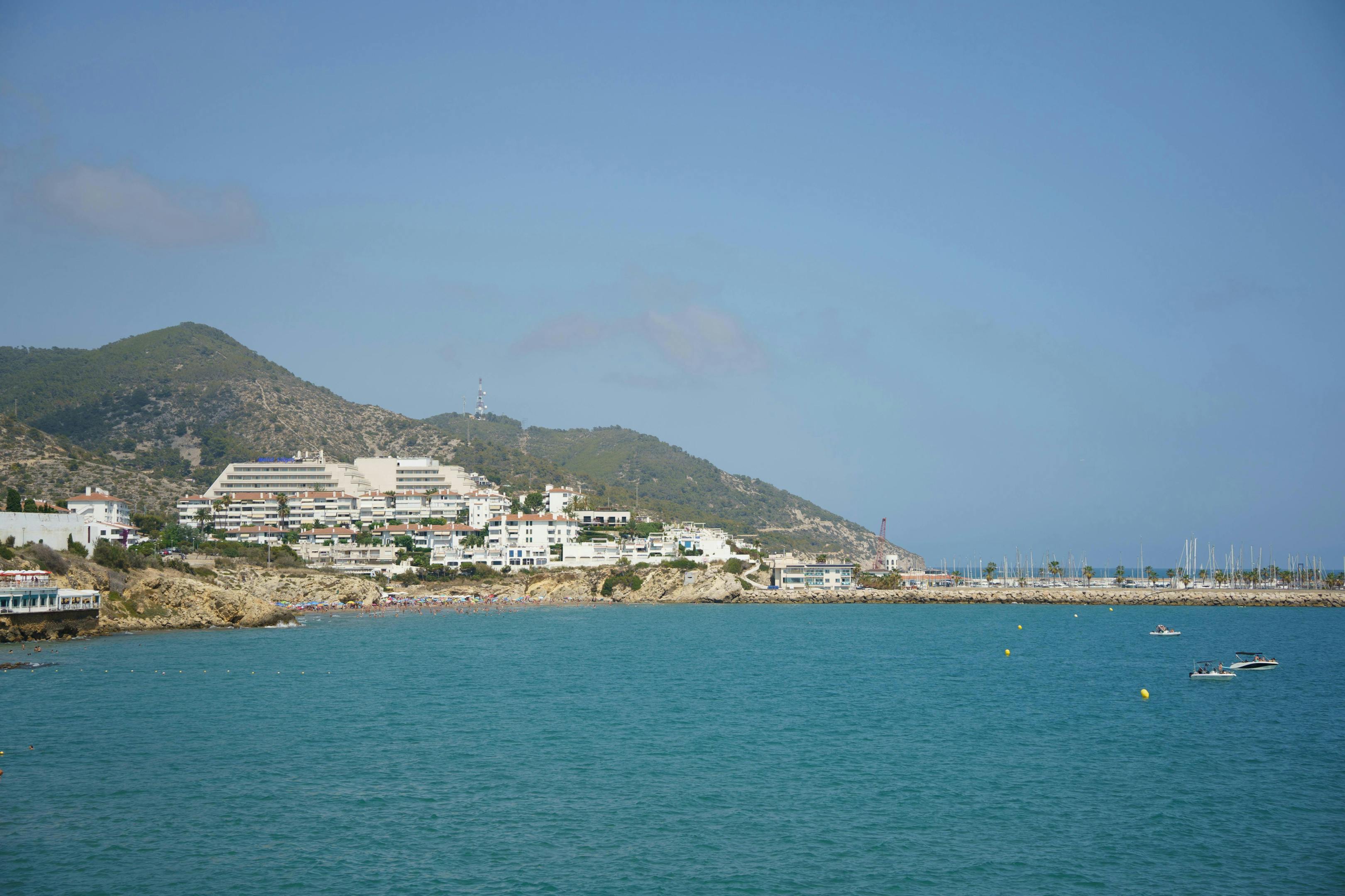 A scenic beach with a charming harbor in Sitges, offering a picturesque view of the town's coastal beauty.