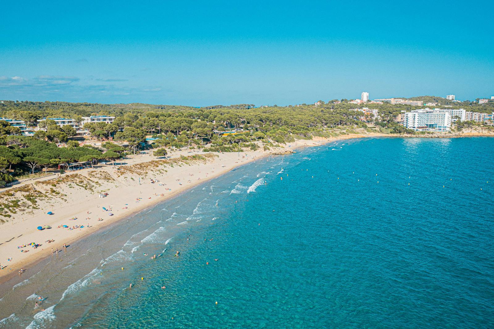 Beachgoers enjoying the water at Llarga Beach, Salou.