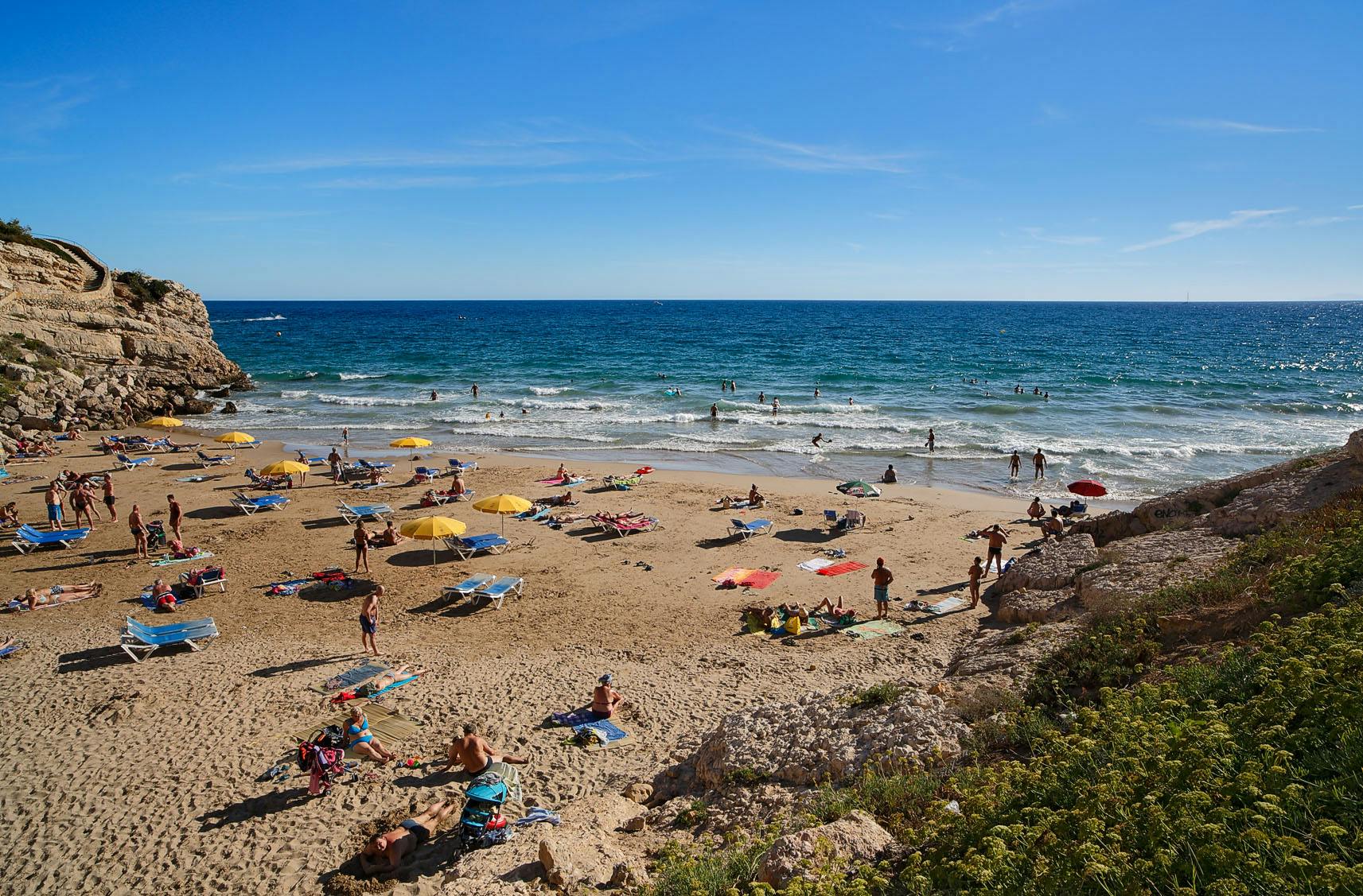 People relaxing on the sandy beach at Llenguadets Beach, Salou.