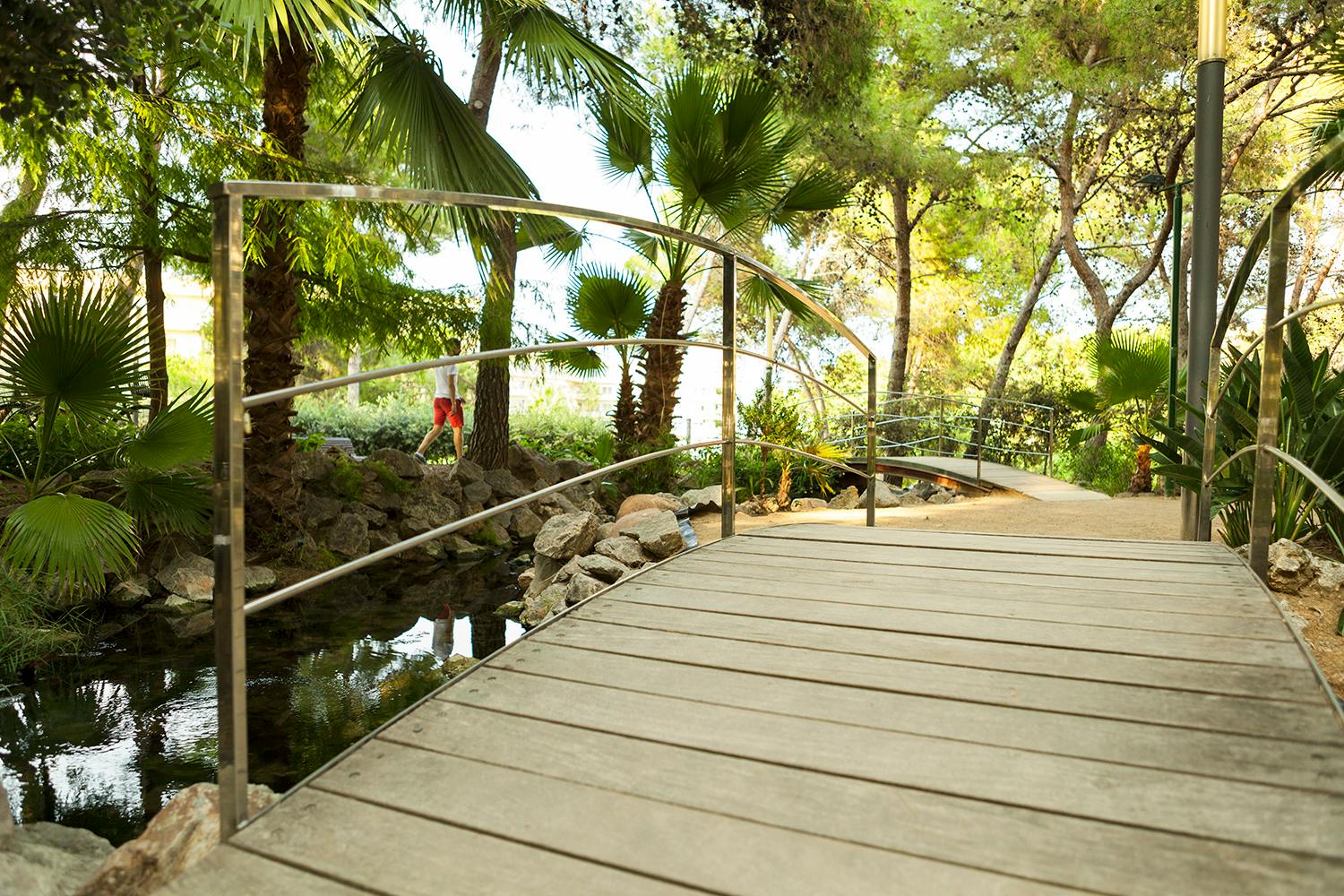 A wooden bridge over a pond in Parc de la Ciutat, Salou.