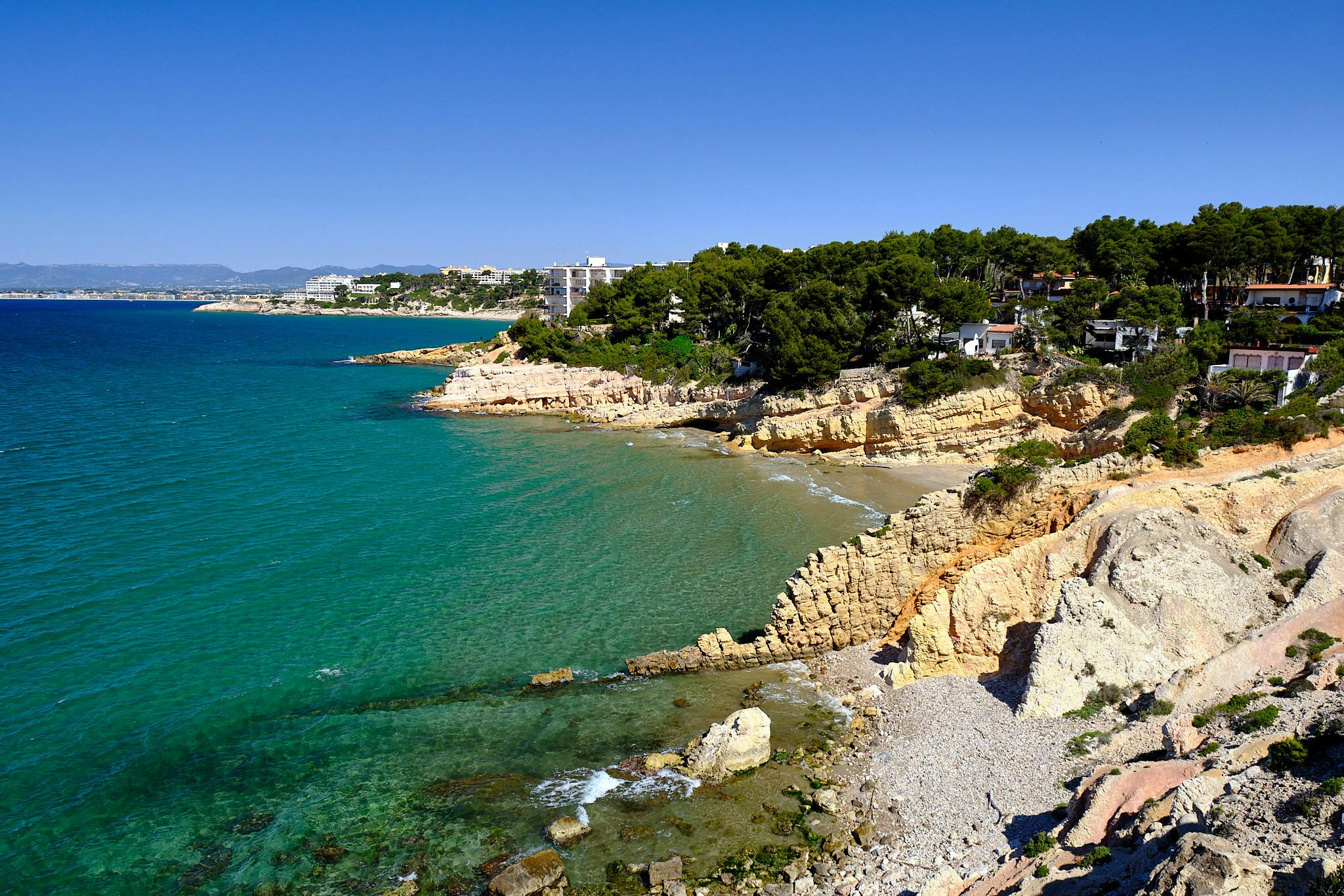 Beachfront houses lining the shore at Cala Penya Tallada, Salou.