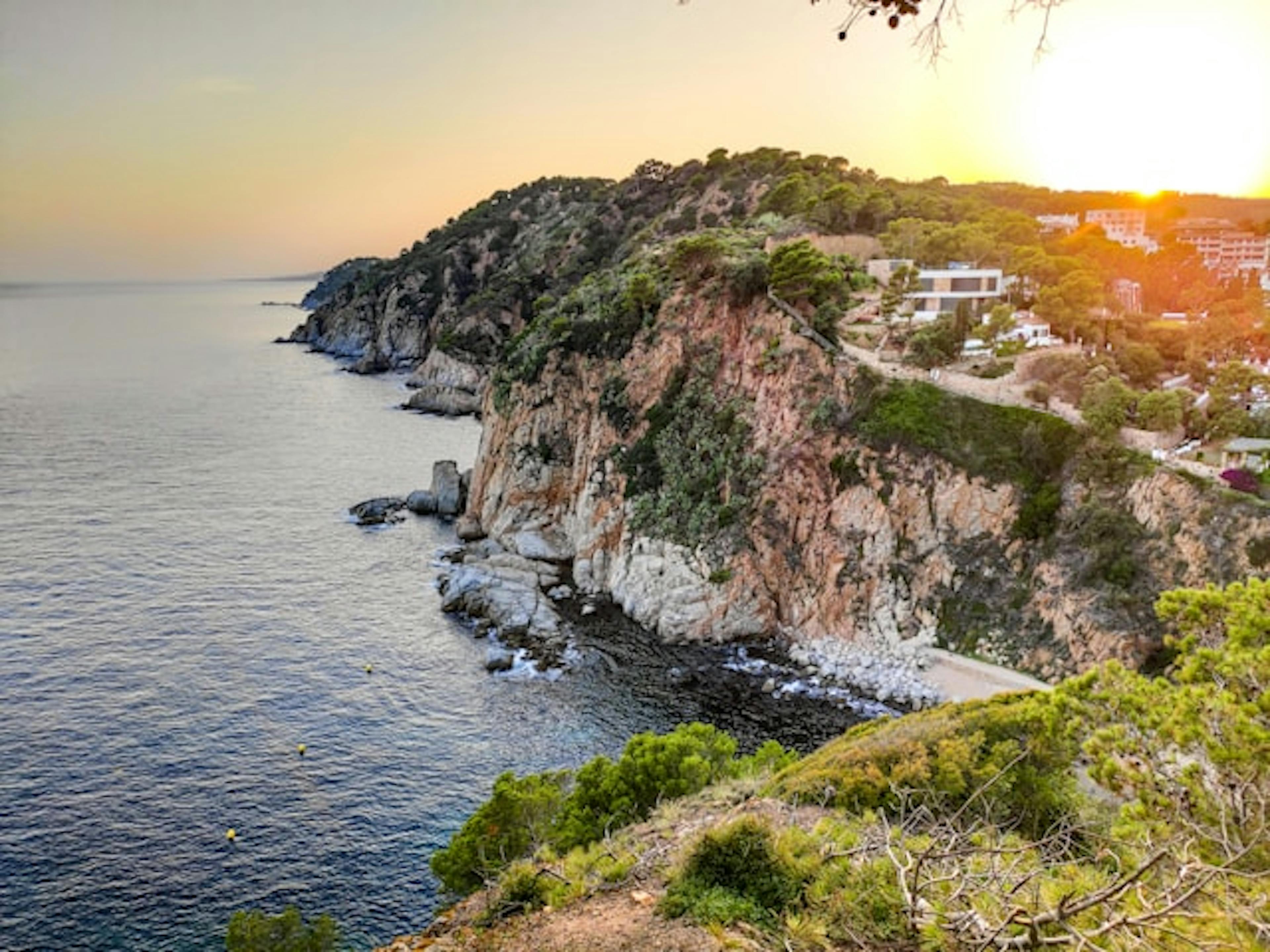 Tranquil beach landscape in Tossa de Mar featuring clear blue ocean waves.