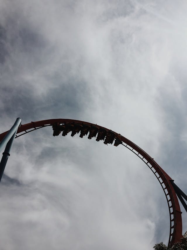 Roller coaster under grey sky during daytime.