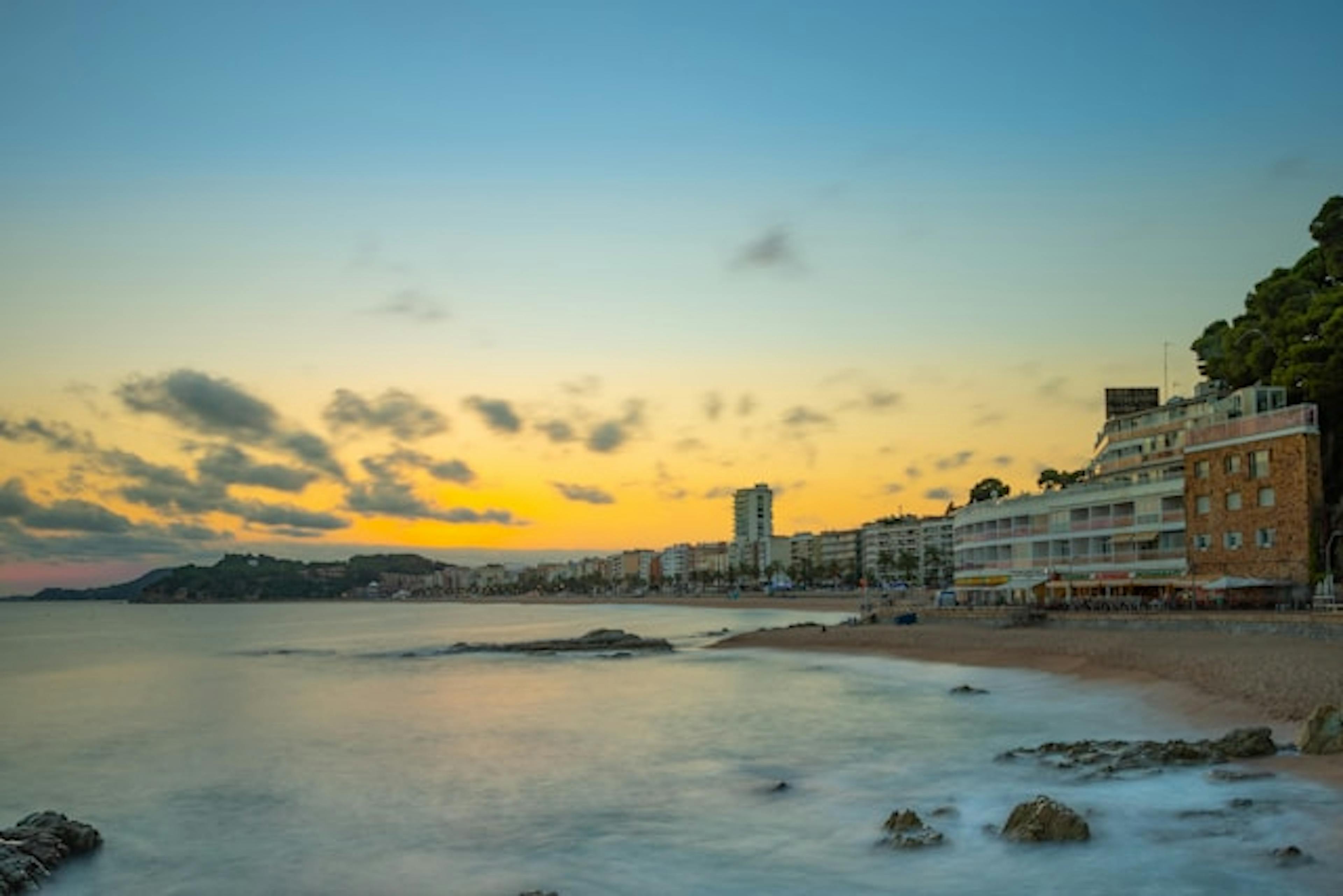 A serene rocky beach in Lloret de Mar, offering a picturesque coastal landscape.