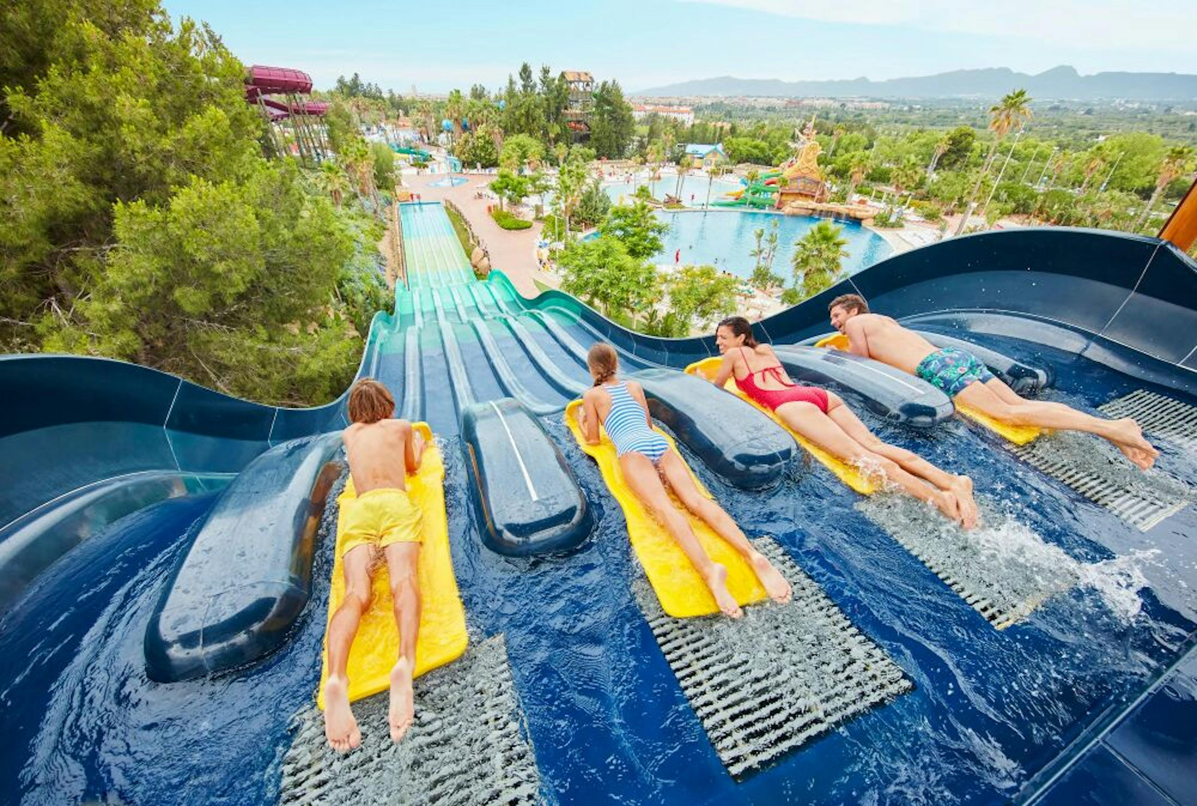 A group of people enjoying a thrilling ride on a water slide, experiencing the excitement and fun of sliding down together.