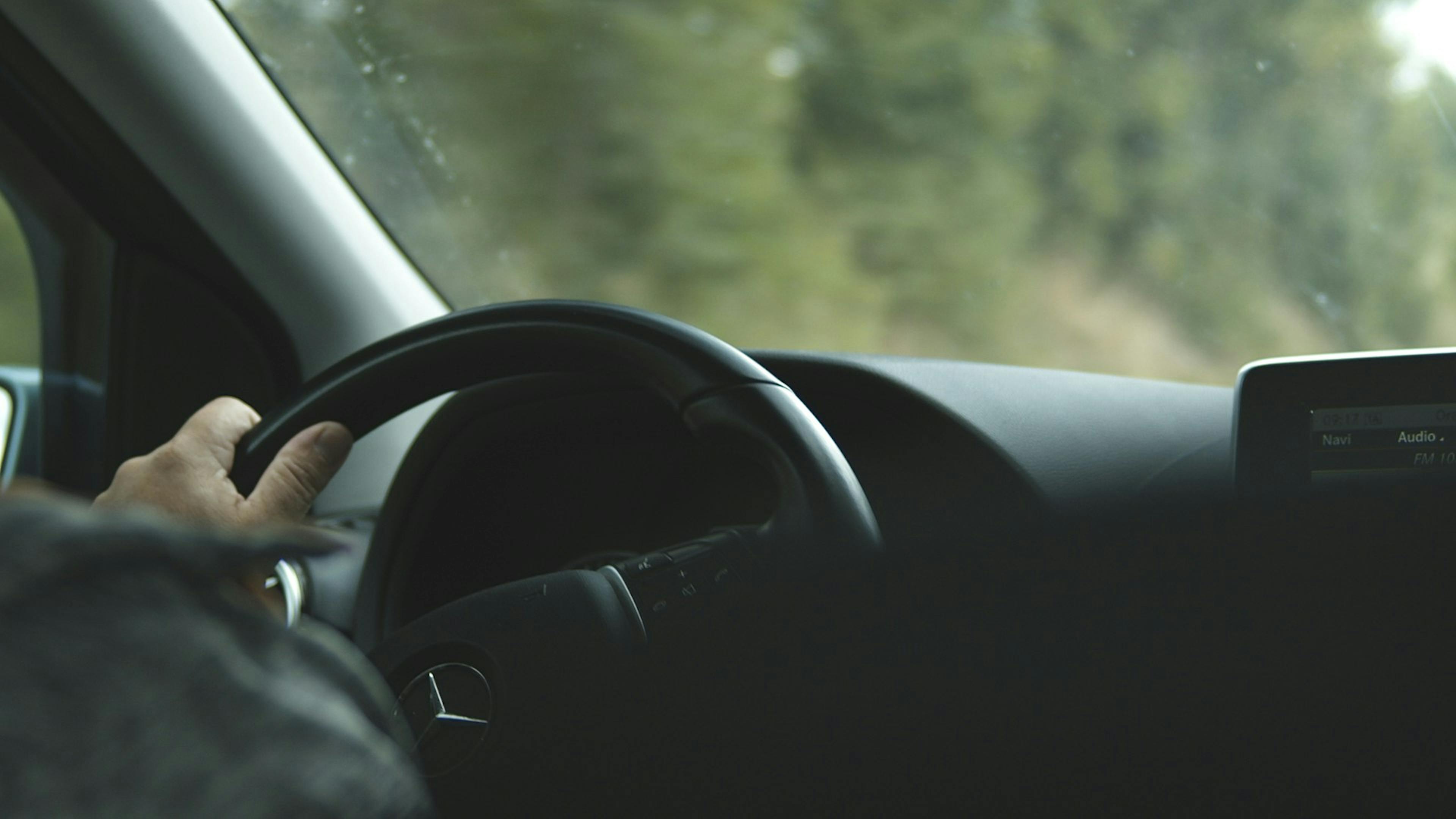 Une personne conduisant une voiture de luxe.