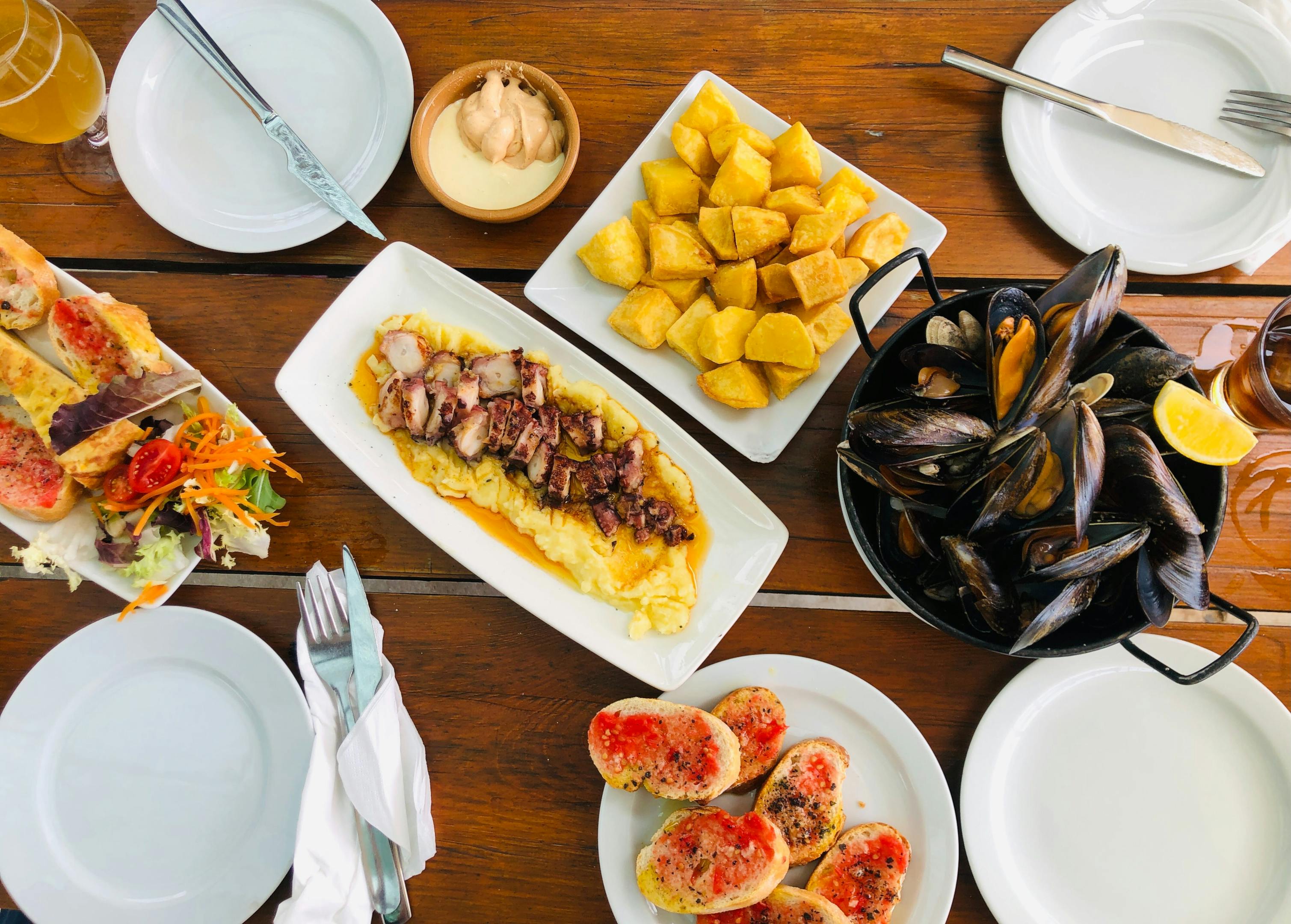 A table filled with delectable tapas and cold beer in a lively tapas bar.