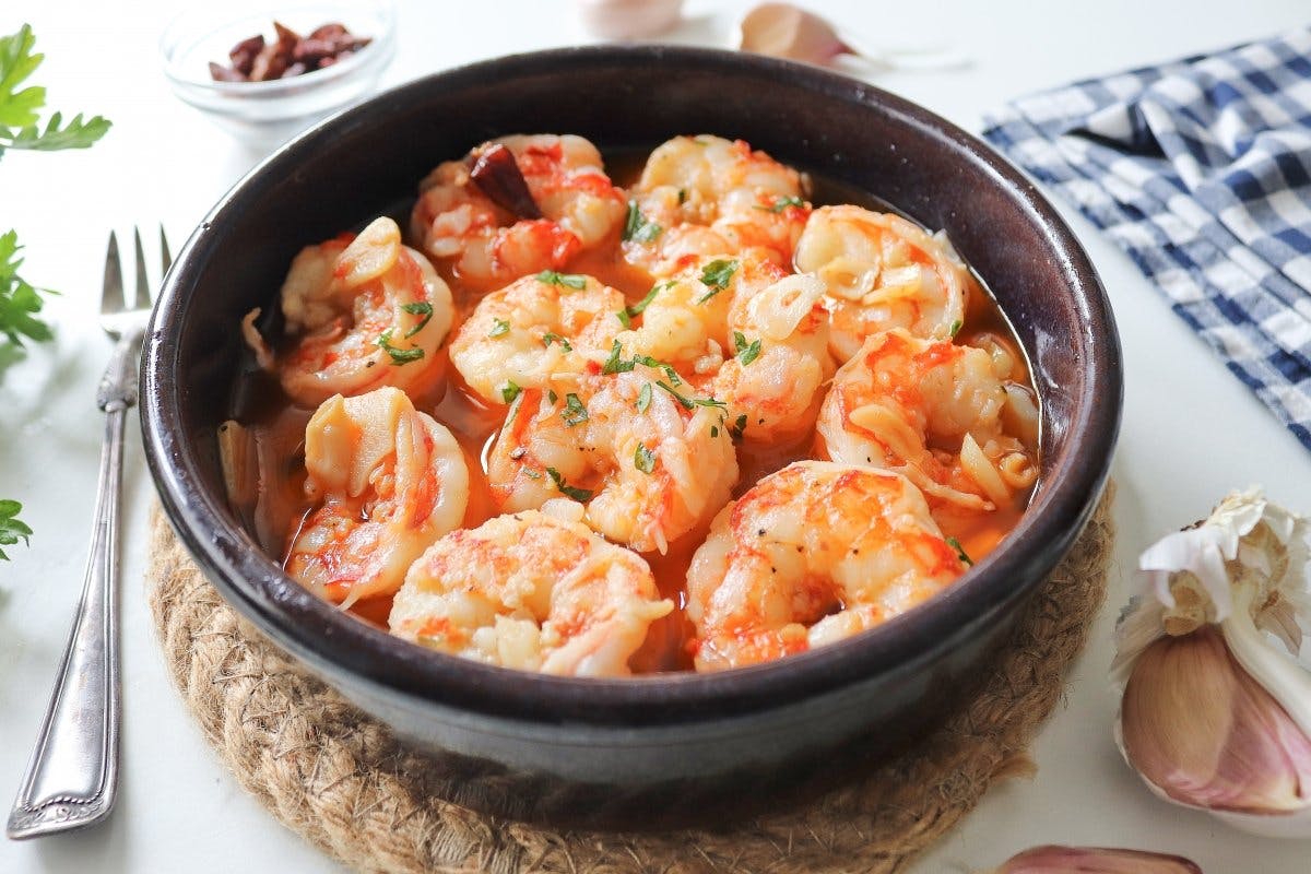 Shrimp in tomato sauce, known as "gambas al ajillo," served in a bowl. A delicious and flavorful dish.