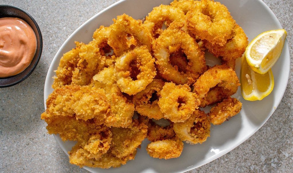 Fried calamari with a lemon wedge, served at a tapas restaurant.