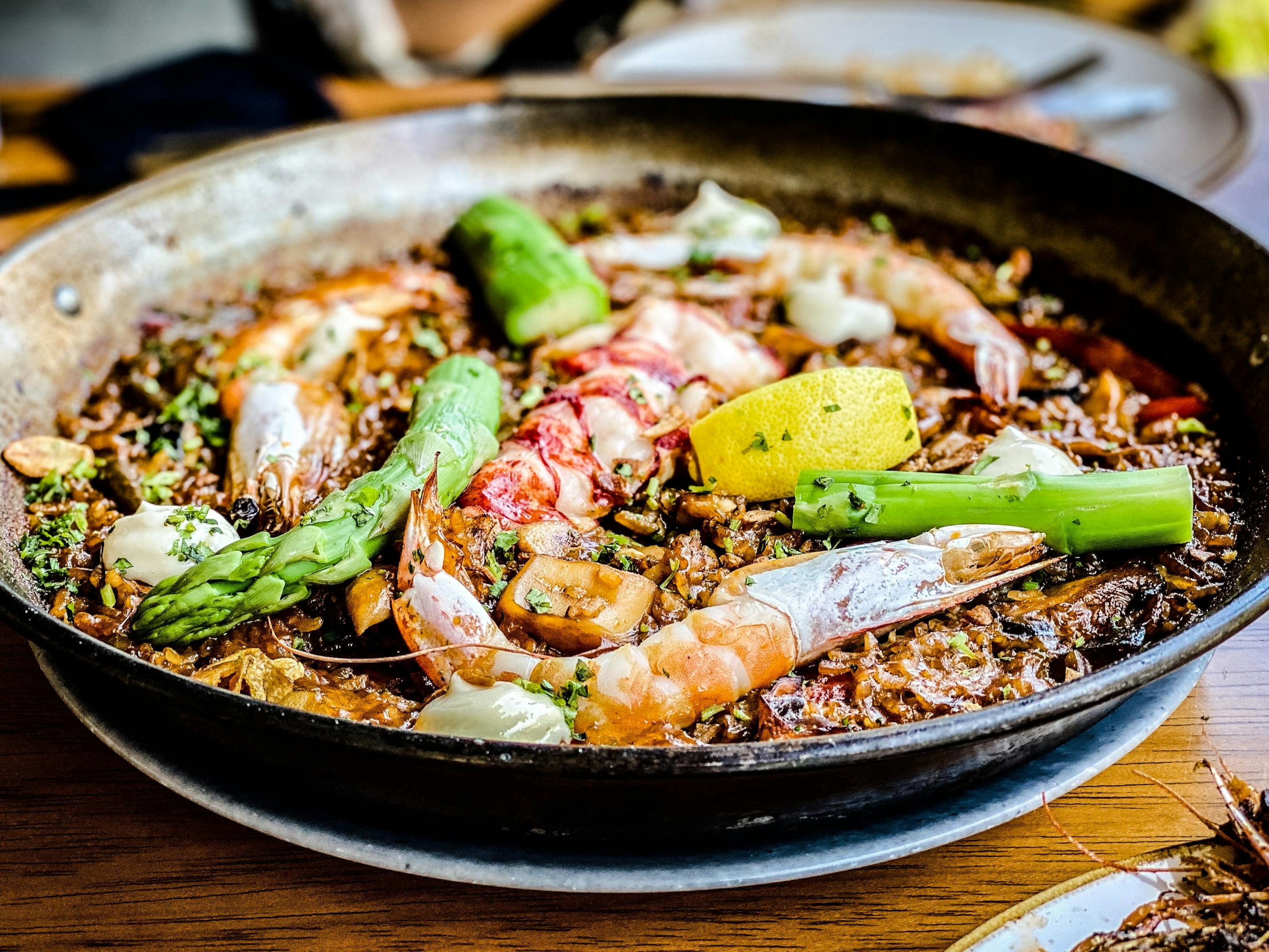 A restaurant serve delicious paella dish with fresh seafood and vegetables.