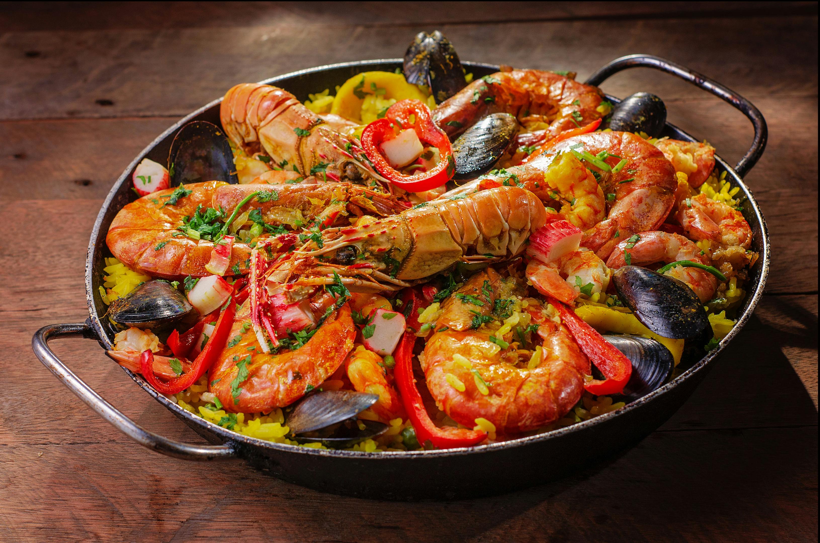 An appetizing pan of paella de mariscos, showcasing a mouthwatering blend of seafood and rice.