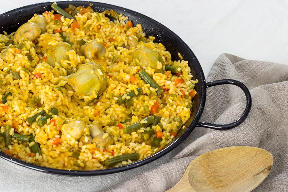 A delicious paella de verduras, a pan filled with rice and vegetables, cooked to perfection.