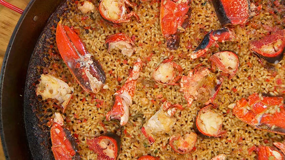 A pan filled with Paella de bogavante, a delicious lobster and rice dish.