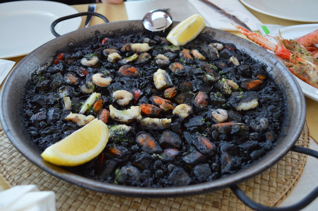 A savory pan of paella negra, featuring a delectable blend of seafood