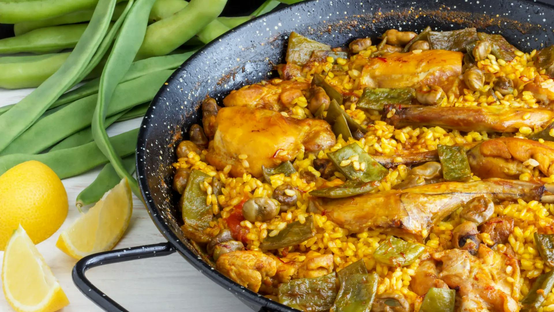 Paella de montaña, a traditional Spanish dish, featuring a pan filled with rice and savory meat.